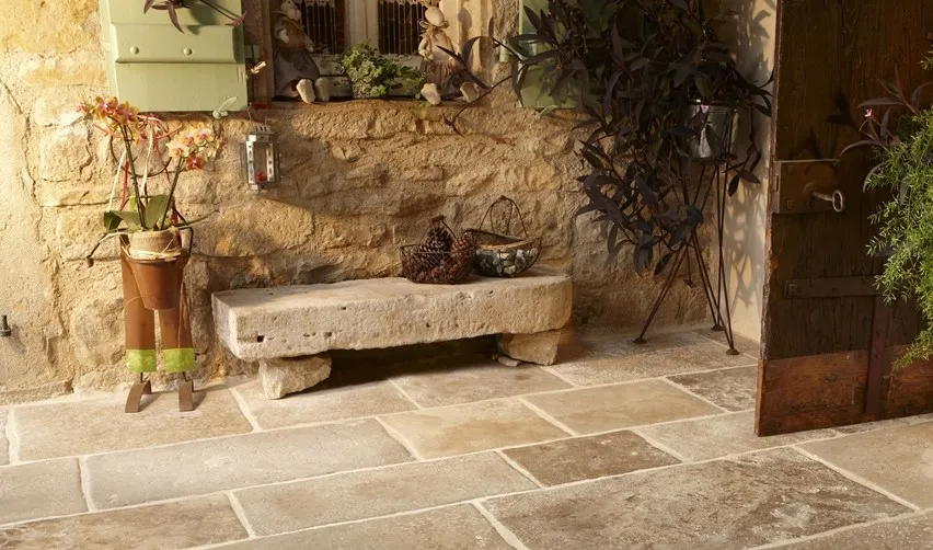 zu sehen ein Außenbereich mit Steinbank und planzen