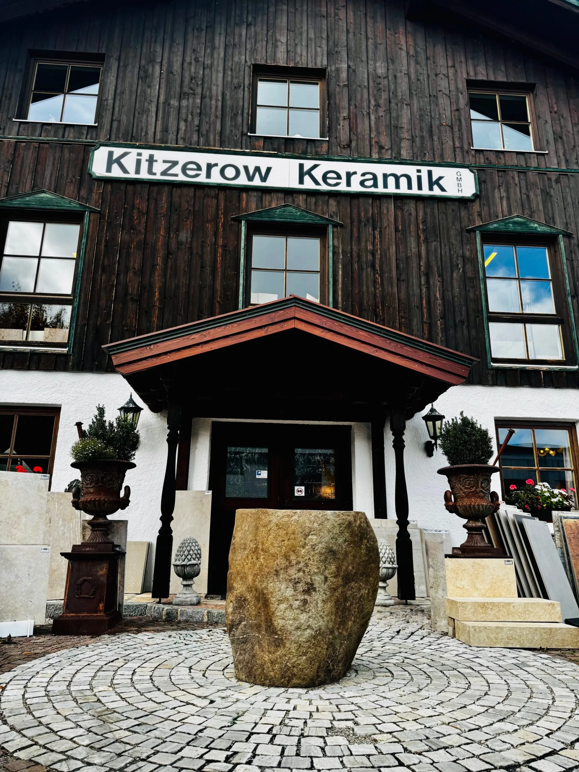 Außeneingang der Firma zu sehen ein Natursteinaußenbecken und Fliesenmuster